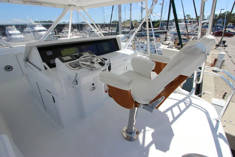 Yacht Photos Pics Helm station of 2004 Hatteras 60 Convertible yacht with captain's chair and navigation controls.