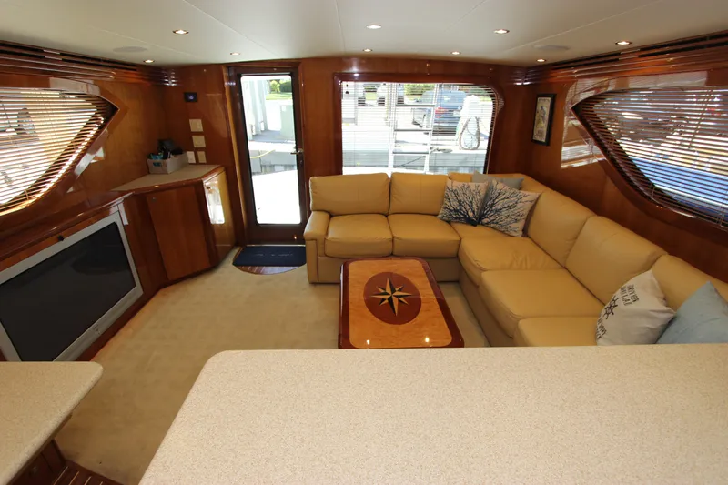  Yacht Photos Pics Luxurious interior of 2004 Hatteras 60 Convertible yacht with beige seating and wooden accents.