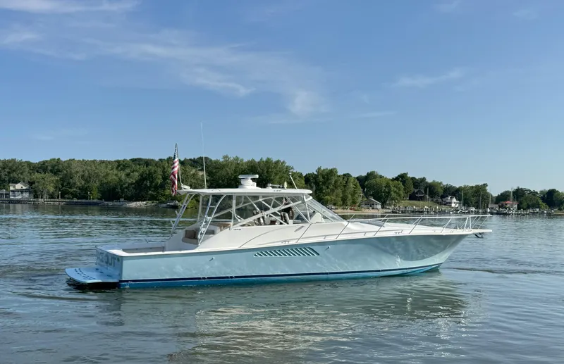 Peace Out Yacht Photos Pics 2007 Viking 52 Open yacht on calm water, surrounded by lush greenery.