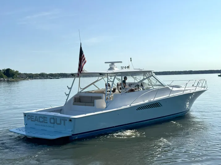 Peace Out Yacht Photos Pics 2007 Viking 52 Open yacht on calm water, displaying "Peace Out" and American flag.