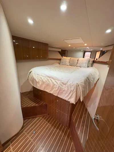 Peace Out Yacht Photos Pics Luxurious bedroom interior of 2007 Viking 52 Open yacht with wooden flooring and cozy bedding.