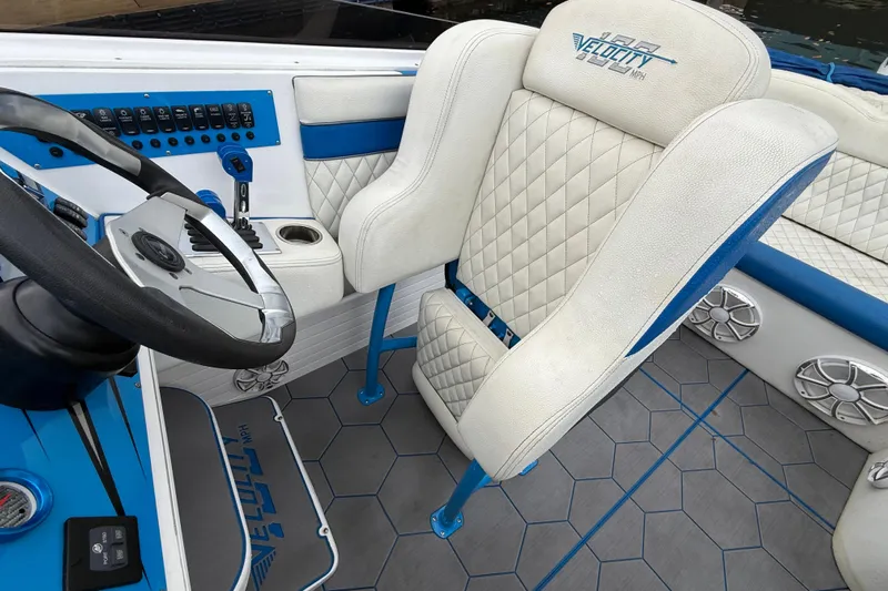  Yacht Photos Pics Interior of 2021 Velocity 290sc boat with white and blue seating and steering wheel.