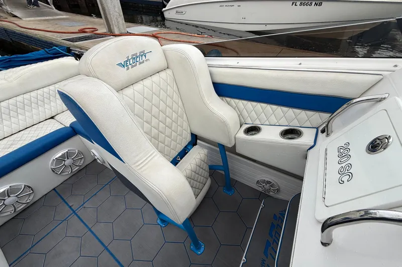  Yacht Photos Pics 2021 Velocity 290sc boat interior with white and blue seating, cup holders, and speakers.