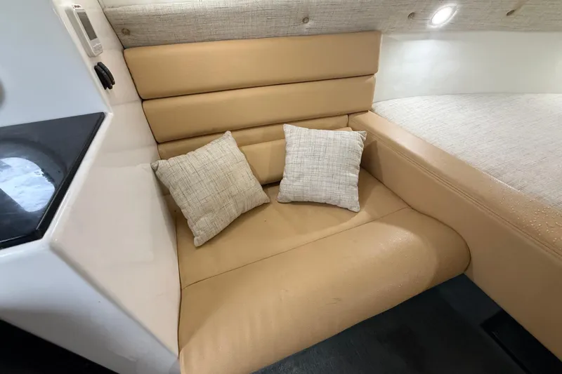  Yacht Photos Pics Cozy seating area in 2021 Velocity 290sc boat with beige cushions and pillows.