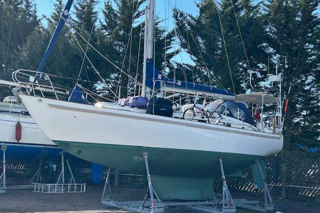 Sailboat on stands, Rival 36 model, 1995, surrounded by trees.