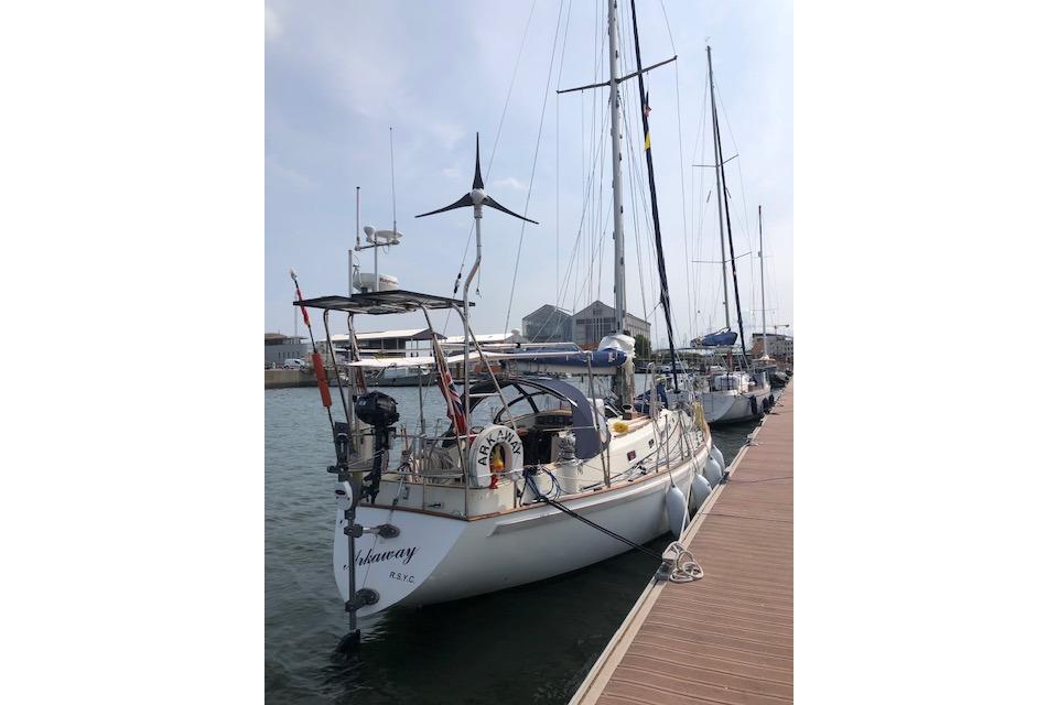 Sailboat docked at marina, Rival 36 model, 1995, with wind turbine and equipment.