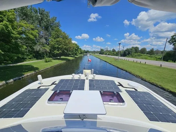 Carmella Yacht Photos Pics Kadey-Krogen 44AE 2019 yacht cruising on a scenic canal with solar panels.