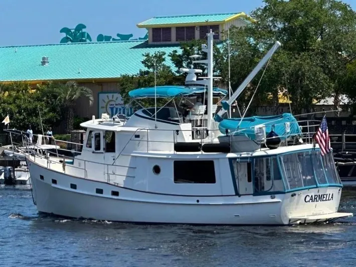 Carmella Yacht Photos Pics Kadey-Krogen 44AE 2019 yacht "Carmella" cruising near a colorful waterfront building.