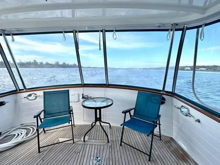 Carmella Yacht Photos Pics Kadey-Krogen 44AE 2019 yacht deck with chairs and table overlooking serene water.