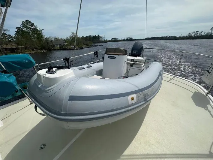 Carmella Yacht Photos Pics 2019 Kadey-Krogen 44AE boat with inflatable dinghy on deck, docked by a scenic river.