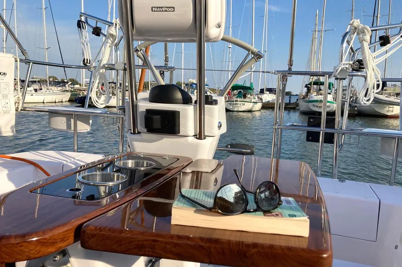 Sea Fever IV Yacht Photos Pics 2022 Catalina 355 sailboat cockpit with sunglasses and book, docked in marina.