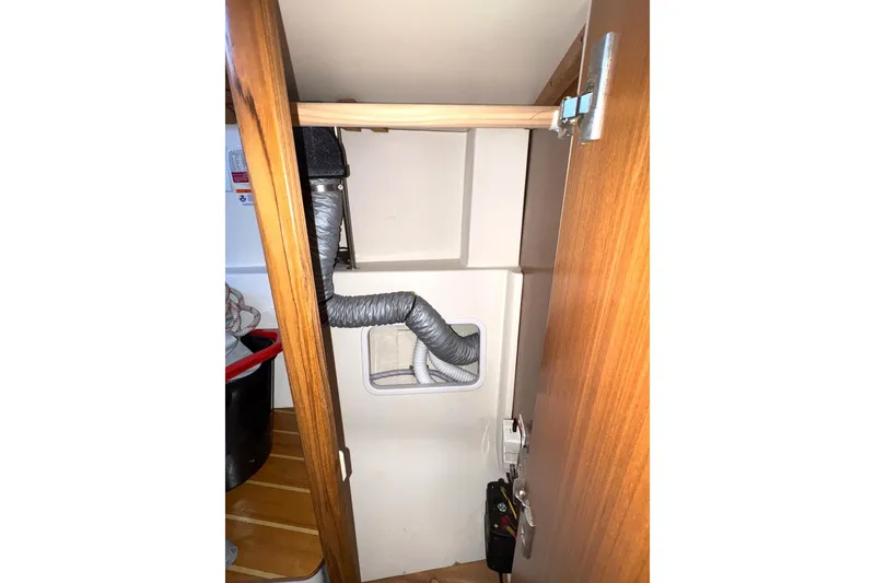 Sea Fever IV Yacht Photos Pics Interior view of a 2022 Catalina 355 sailboat storage compartment with ventilation hose.