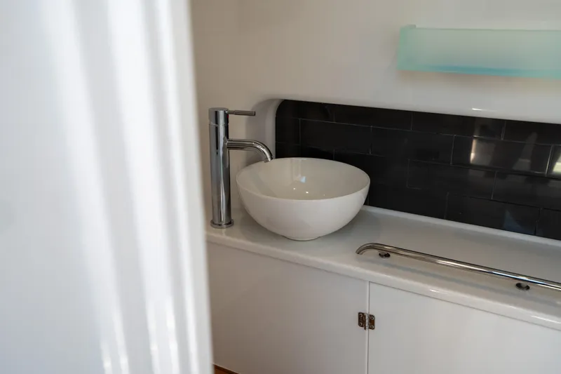  Yacht Photos Pics Modern bathroom sink in 2024 Blackfin 400CC boat, featuring sleek design and black tile backsplash.