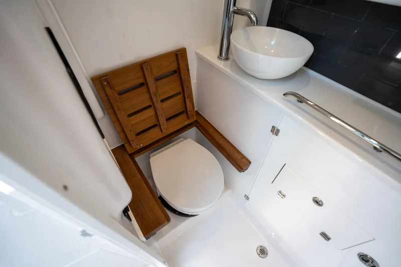  Yacht Photos Pics 2024 Blackfin 400CC boat bathroom with wooden seat, modern sink, and sleek design.