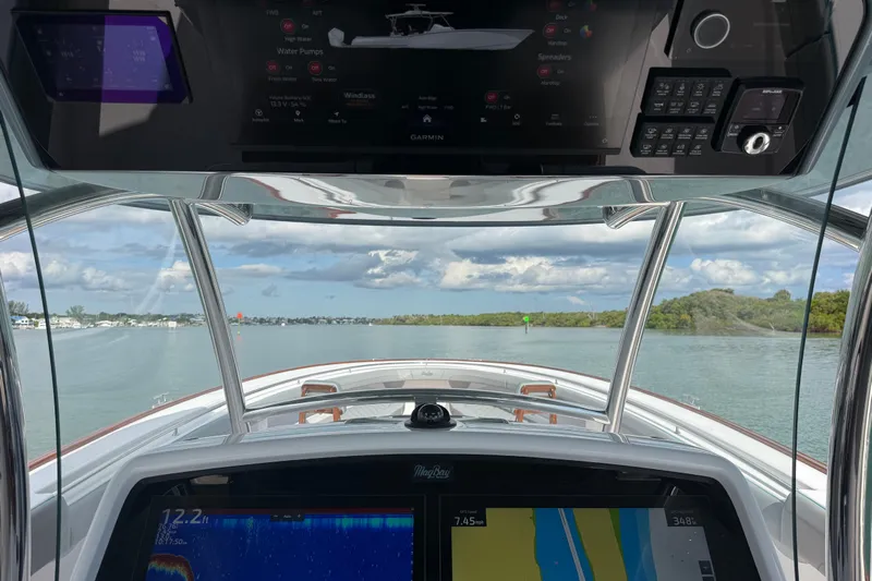  Yacht Photos Pics Interior view of 2026 Mag Bay 43 CC boat with navigation screens and scenic waterway.