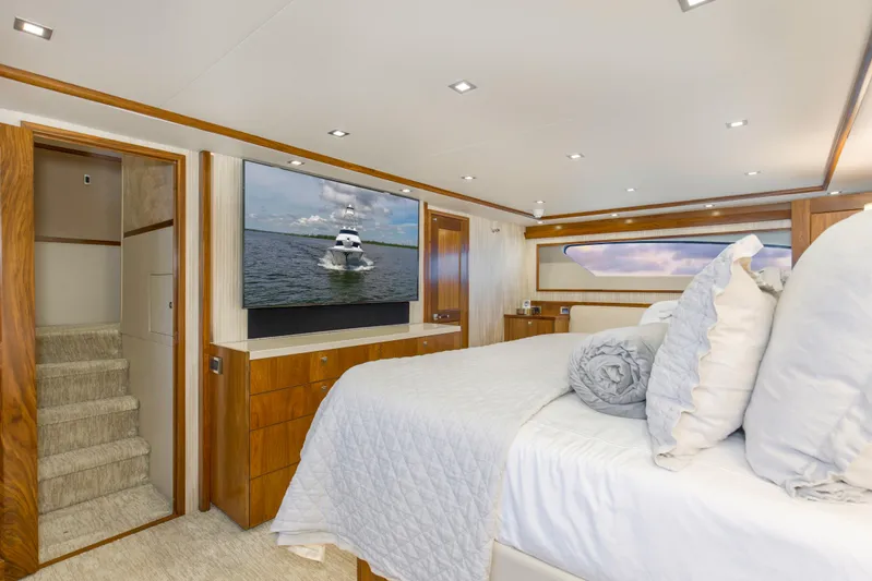 Touche Yacht Photos Pics Luxurious bedroom interior of 2016 Viking 92 Enclosed Bridge yacht with TV and elegant decor.