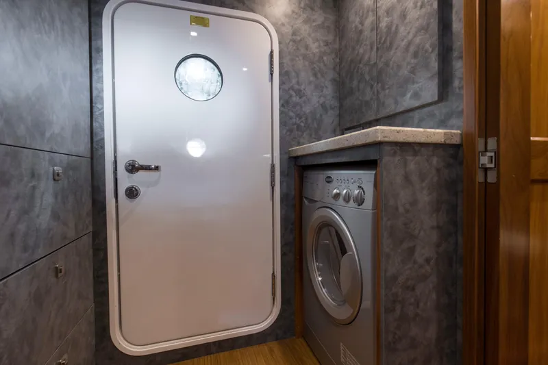 Touche Yacht Photos Pics Laundry area on 2016 Viking 92 Enclosed Bridge yacht with washer and porthole door.