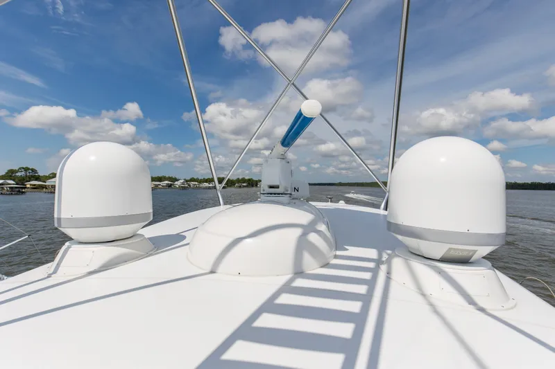 Touche Yacht Photos Pics 2016 Viking 92 Enclosed Bridge yacht deck with radar domes and clear sky.