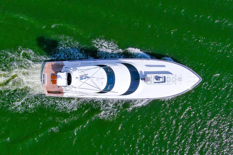 Touche Yacht Photos Pics Aerial view of 2016 Viking 92 Enclosed Bridge yacht cruising on green water.