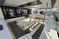 Spacious deck of a 2020 Leopard 45 catamaran with seating and table.