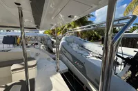 Leopard 45 catamaran deck with inflatable boat, 2020 model, docked near palm trees.