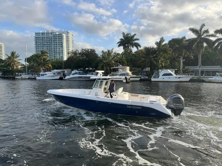  Yacht Photos Pics 2011 Everglades 320 Center Console boat cruising on a scenic waterway with palm trees.
