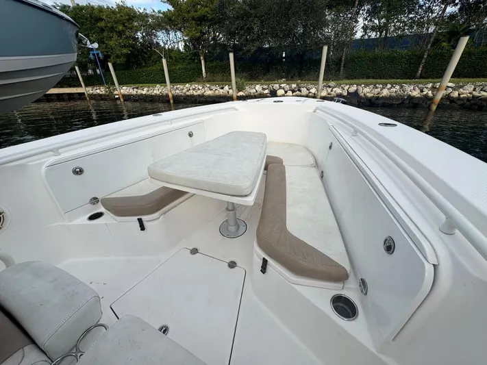  Yacht Photos Pics 2011 Everglades 320 Center Console boat interior with seating and table, docked by the water.