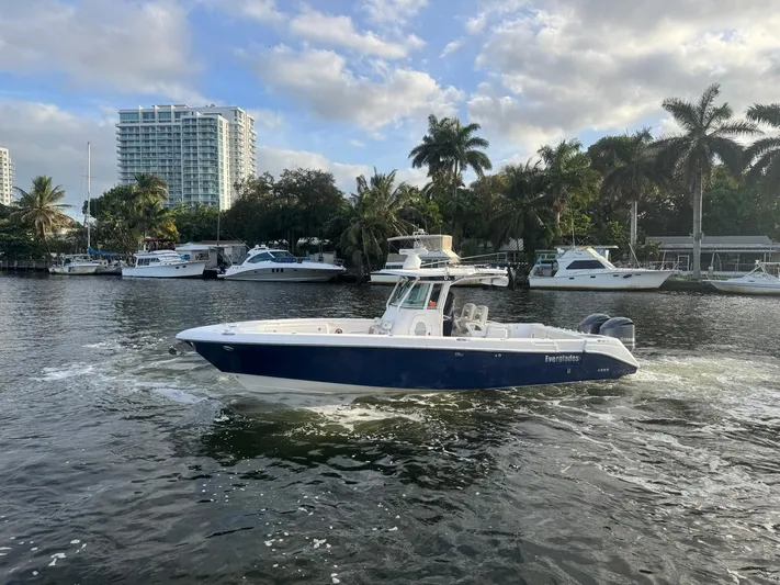  Yacht Photos Pics 2011 Everglades 320 Center Console boat cruising on a scenic waterway with palm trees.
