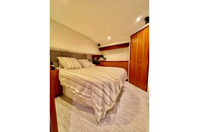  Yacht Photos Pics Luxurious bedroom interior of 2013 Hatteras GT60 yacht with cozy bed and wooden cabinetry.