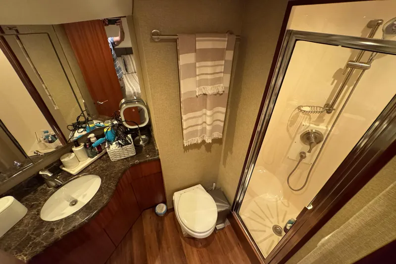  Yacht Photos Pics Luxurious bathroom in 2013 Hatteras GT60 yacht with shower, sink, and wooden accents.