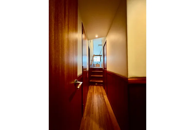  Yacht Photos Pics Interior hallway of 2013 Hatteras GT60 yacht with wooden paneling and stairs.