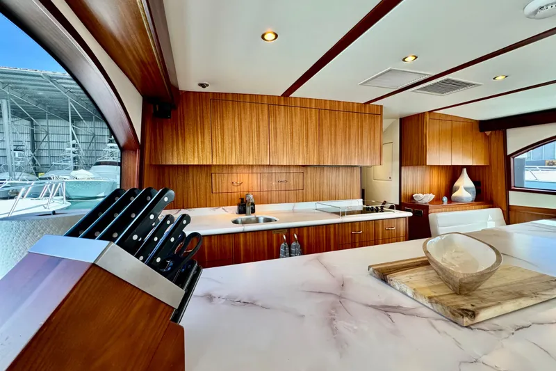  Yacht Photos Pics Luxurious 2013 Hatteras GT60 yacht kitchen with wood cabinetry and marble countertops.