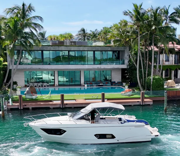  Yacht Photos Pics Luxury yacht Absolute 40 cruising by a modern waterfront villa with palm trees.