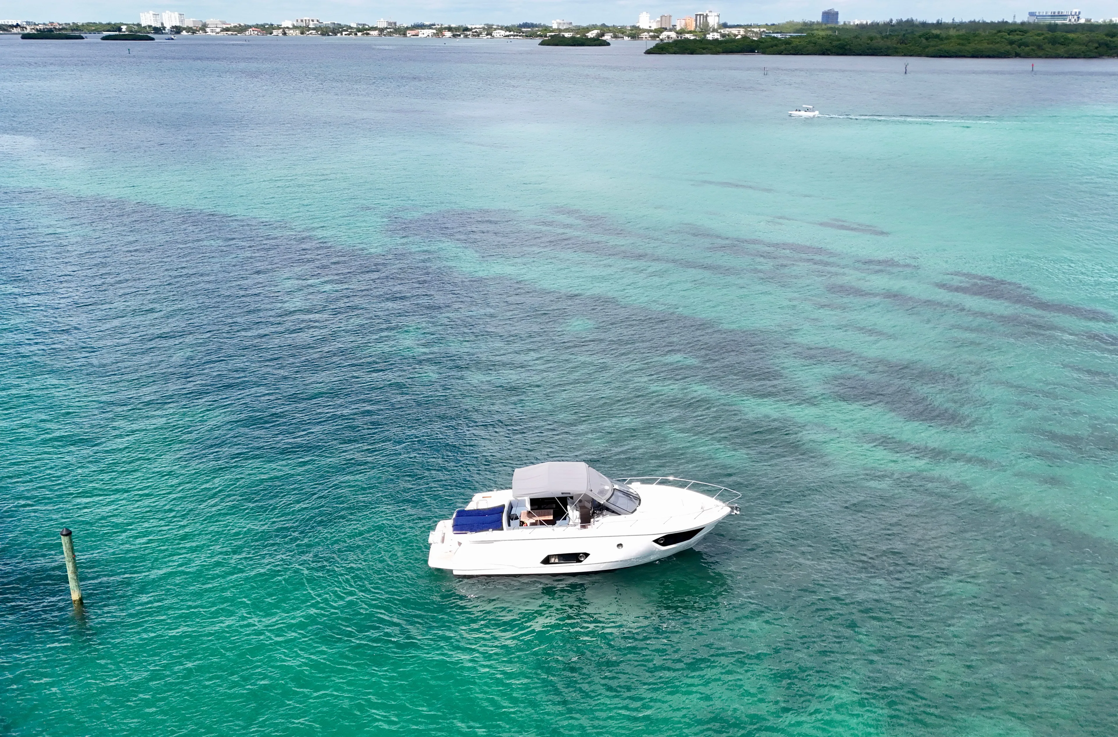  Yacht Photos Pics A 2014 Absolute 40 yacht cruising on clear turquoise waters near a distant shoreline.