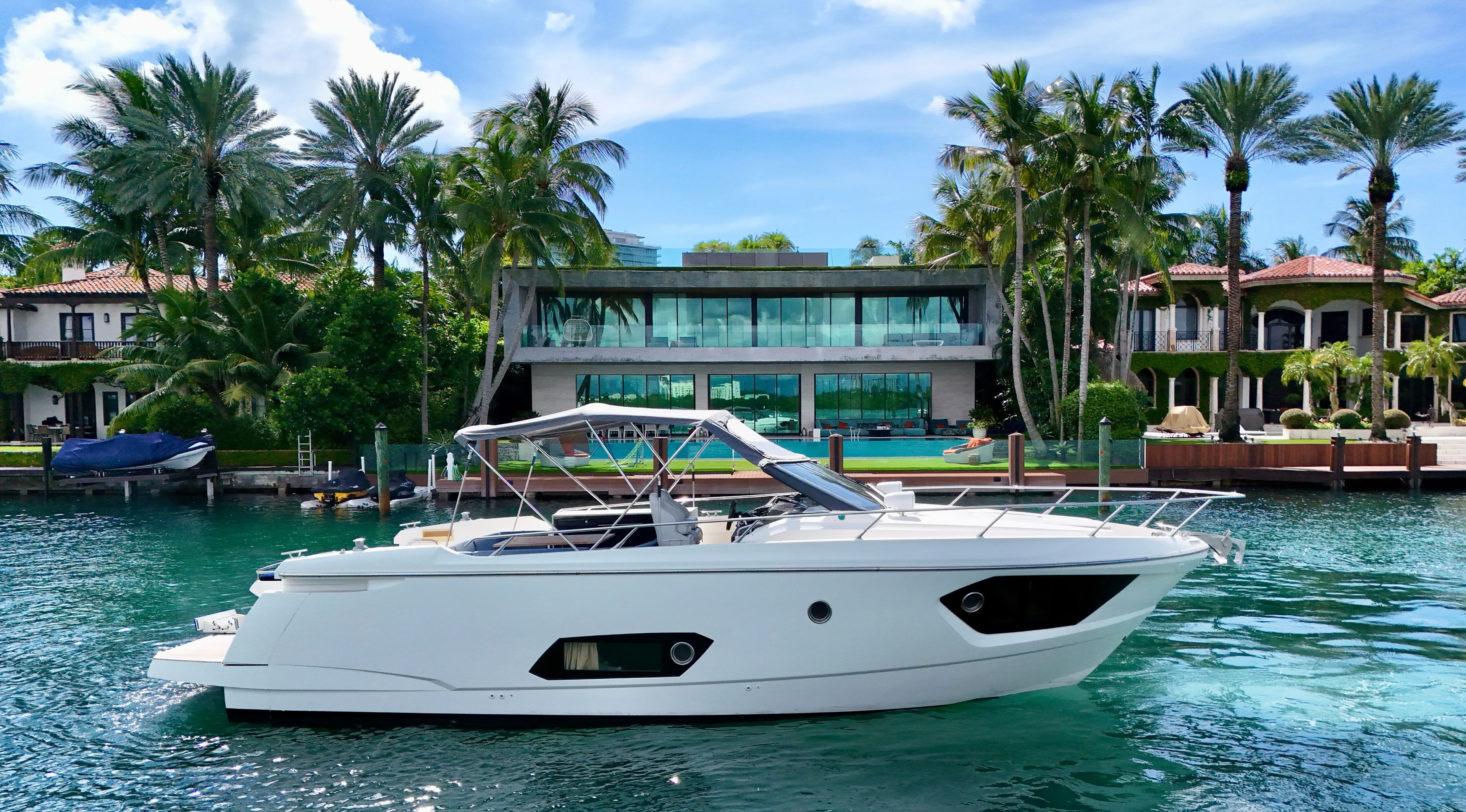  Yacht Photos Pics Luxury Absolute 40 yacht cruising near waterfront mansion, surrounded by palm trees.
