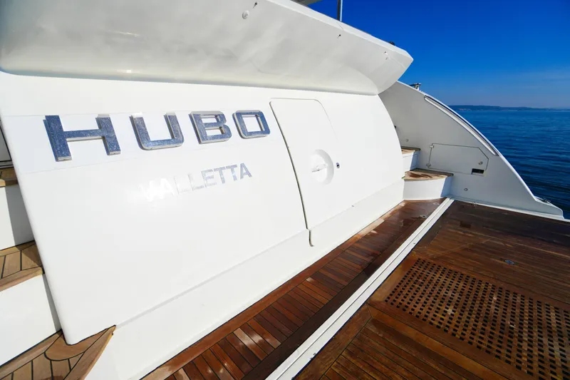 Hubo Yacht Photos Pics Azimut 84 yacht, 2016 model, with wooden deck and "HUBO" lettering, docked by the sea.