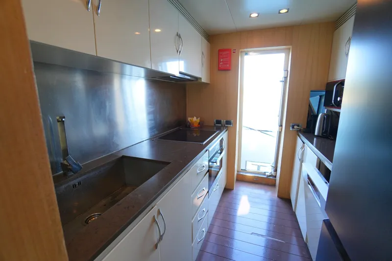 Hubo Yacht Photos Pics Modern kitchen interior on 2016 Azimut 84 yacht, featuring sleek countertops and stainless steel appliances.
