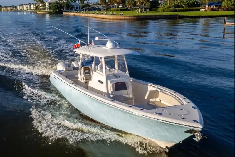  Yacht Photos Pics 2018 Cobia 320 Center Console boat cruising on a calm waterway.