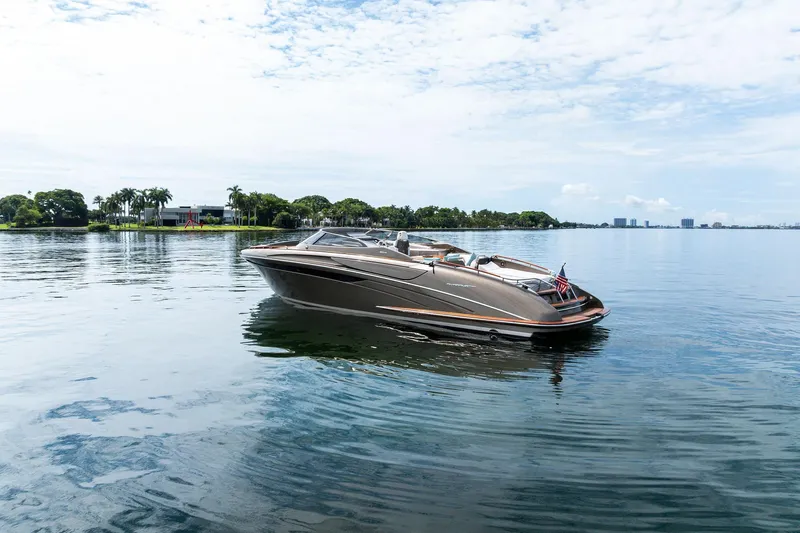 La Sirena Yacht Photos Pics 2014 Riva Rivarama luxury yacht on calm water, with scenic shoreline background.
