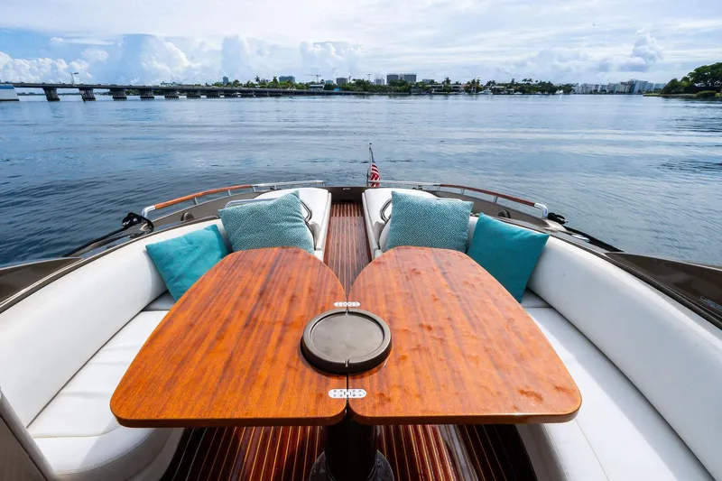 La Sirena Yacht Photos Pics Luxurious 2014 Riva Rivarama yacht interior with elegant wooden table and plush cushions.