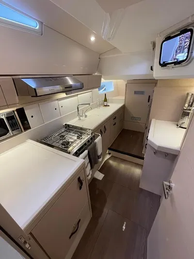 Genesis Yacht Photos Pics Modern kitchen interior of 2021 Jeanneau 54 yacht with sleek cabinetry and appliances.