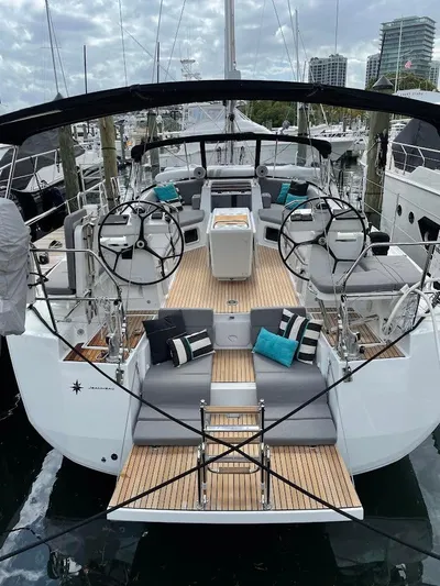 Genesis Yacht Photos Pics 2021 Jeanneau 54 yacht with dual steering wheels and spacious deck, docked at marina.