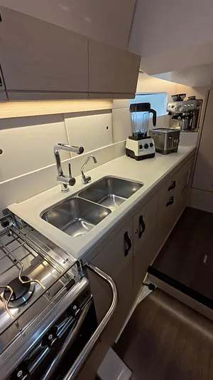 Genesis Yacht Photos Pics Modern kitchen in a 2021 Jeanneau 54 yacht with dual sinks and appliances.