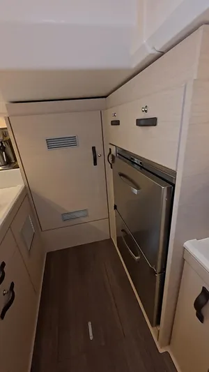 Genesis Yacht Photos Pics Modern kitchen area in a 2021 Jeanneau 54 yacht, featuring sleek cabinetry and appliances.