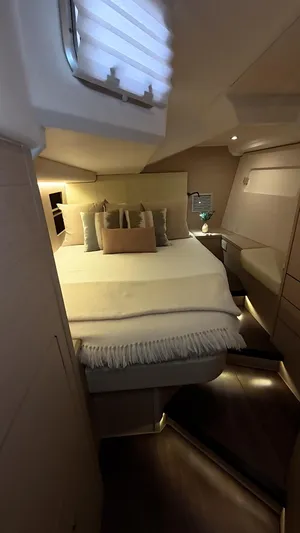 Genesis Yacht Photos Pics Luxurious cabin interior of 2021 Jeanneau 54 yacht with cozy bedding and ambient lighting.