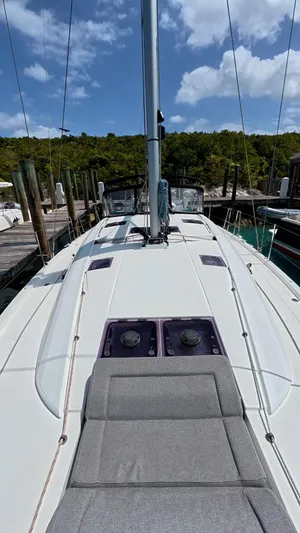 Genesis Yacht Photos Pics 2021 Jeanneau 54 sailboat deck with sunbathing area, docked at marina.
