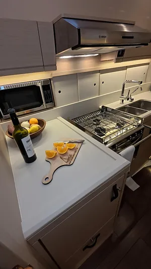 Genesis Yacht Photos Pics Modern kitchen in 2021 Jeanneau 54 yacht with stove, sink, and cutting board.
