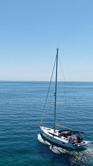 Genesis Yacht Photos Pics 2021 Jeanneau 54 sailing on calm blue ocean under clear sky.