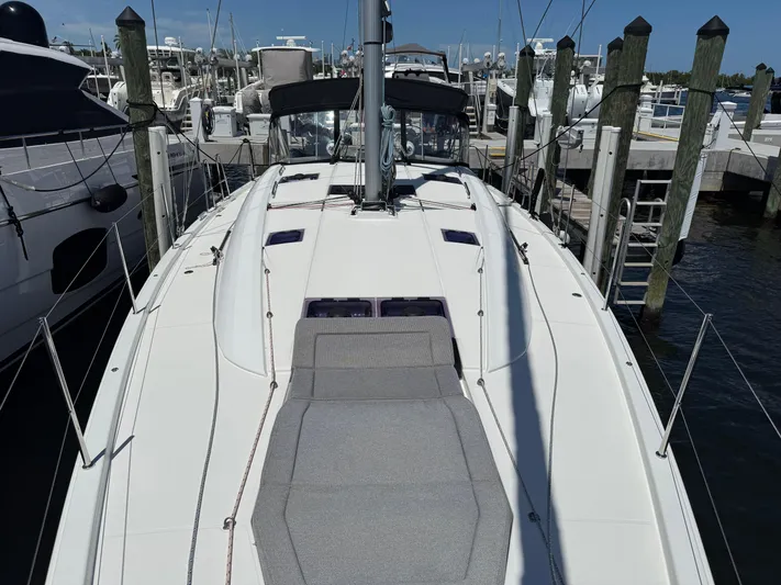 Genesis Yacht Photos Pics Jeanneau 54 yacht, 2021 model, docked at marina with sunbathing area.