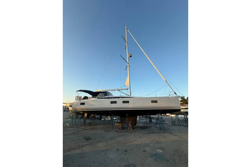 Genesis Yacht Photos Pics 2021 Jeanneau 54 sailboat on dry dock under clear blue sky.